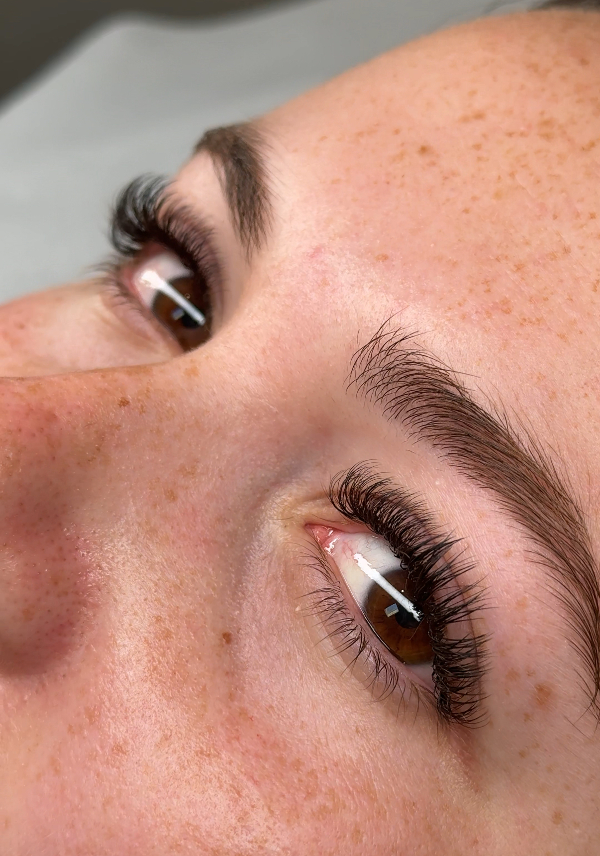 A finished set of eyelash extensions with shaped brows