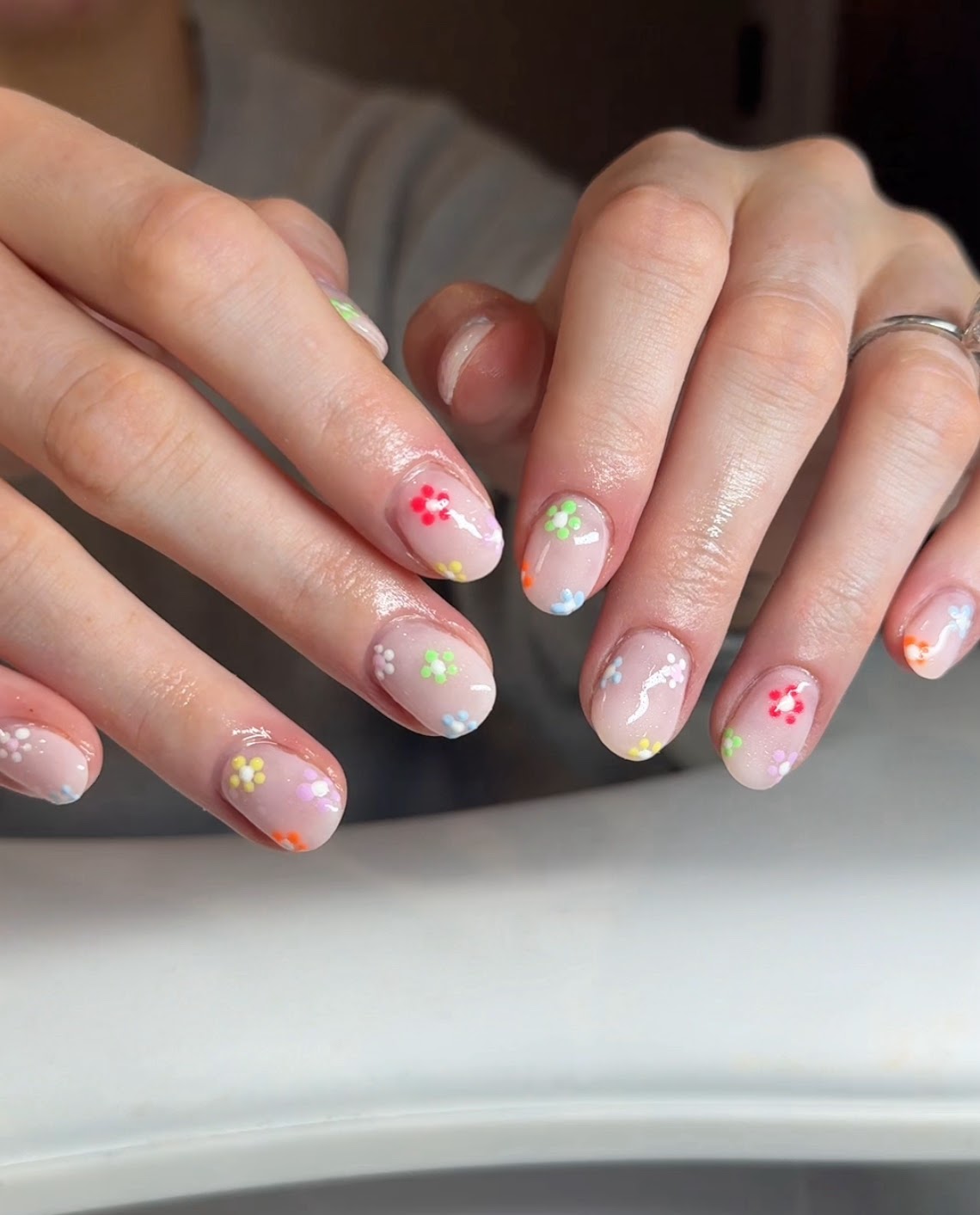 Short natural nails with multicoloured mini daisy art